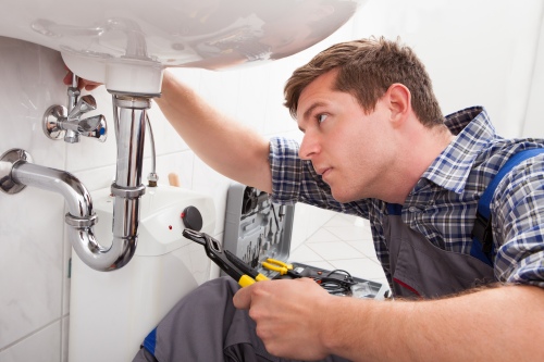 http://Plumber%20performing%20emergency%20repairs%20on%20a%20faulty%20sink