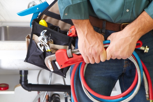 http://Plumber%20standing%20with%20his%20tools%20after%20performing%20emergency%20maintenance
