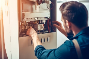 HVAC Technician Fixing Boiler or Furnace to Reduce High Heating Bill
