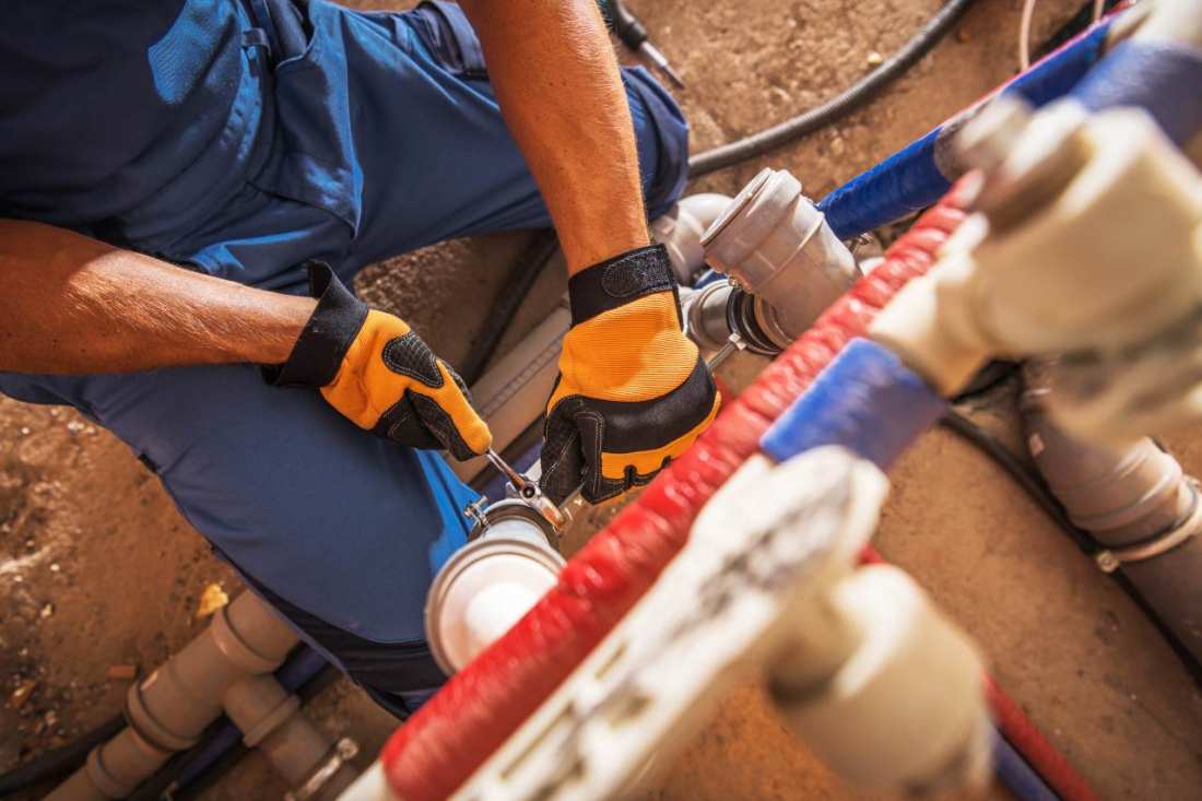 http://Plumbing%20Services%20in%20Irvington,%20NY%20-%20A%20plumber%20uses%20tools%20to%20fix%20piping%20systems%20in%20a%20construction%20setting,%20showcasing%20hands-on%20work%20and%20problem-solving%20skills%20in%20plumbing%20repairs.