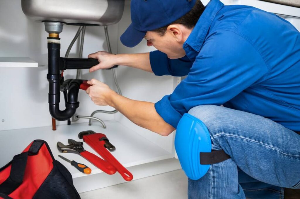 Plumbing Services in Irvington - A an in basin checking and fixing the water tube.