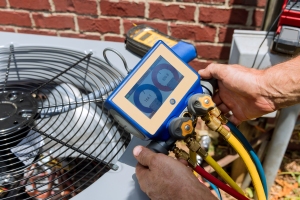 Technician Tuning Up the Outdoor AC Unit with Equipment