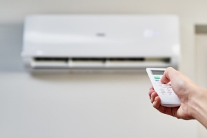 Hand Trying to Switch On AC with Remote