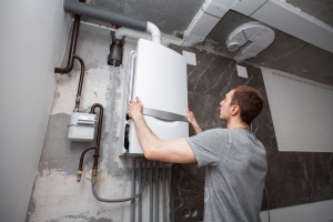 Technician Installing and Setting the New Boiler for Hot Water and Heating